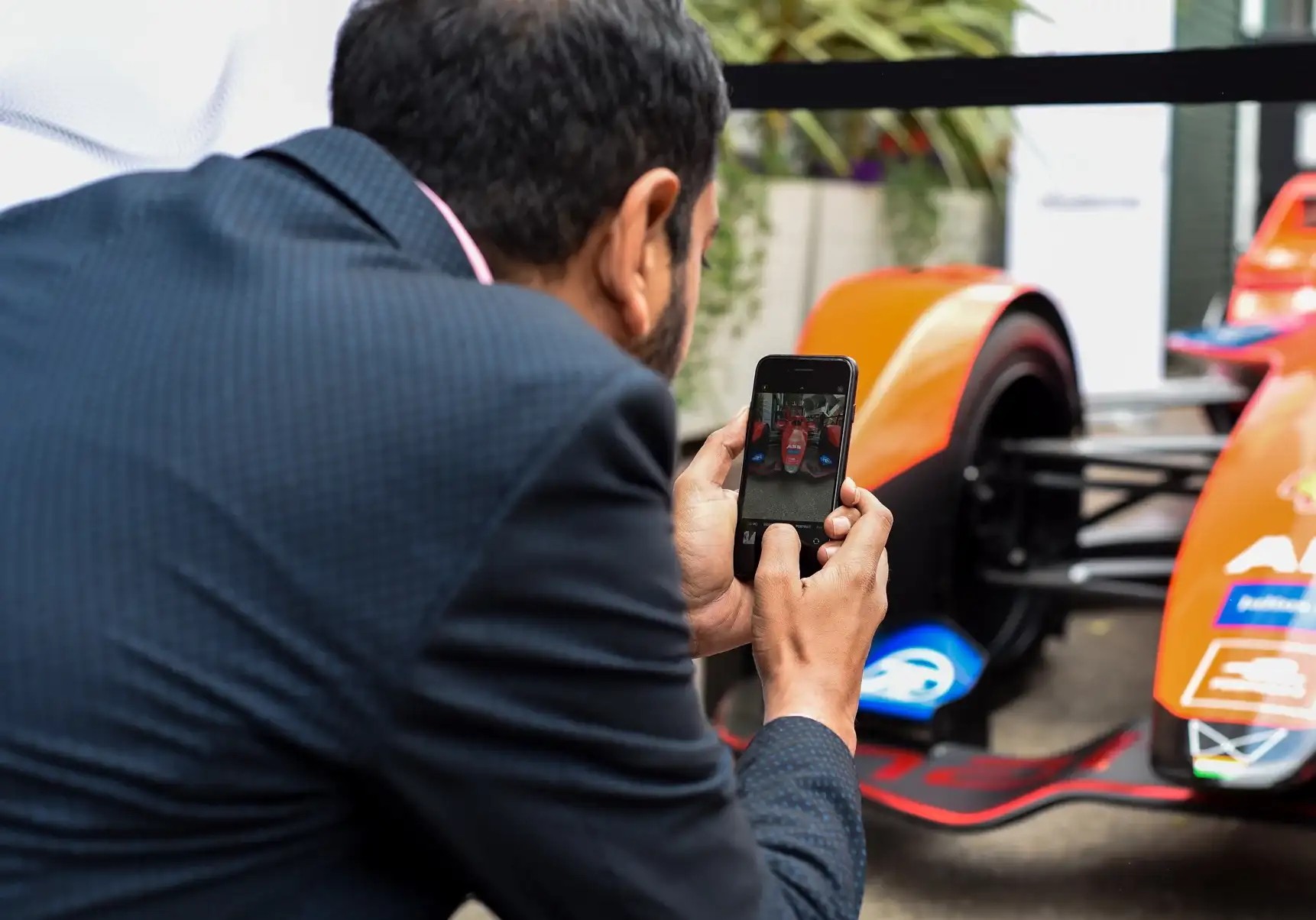 Man photographing a race car with phone